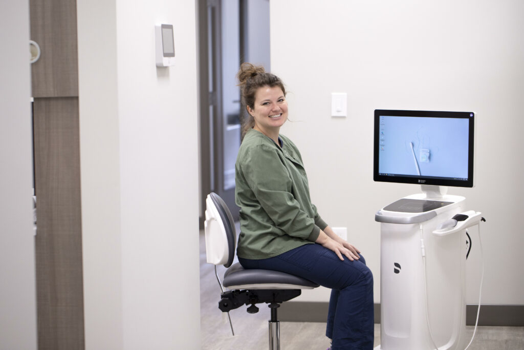 A girl smiling while sitting in front of a dental device