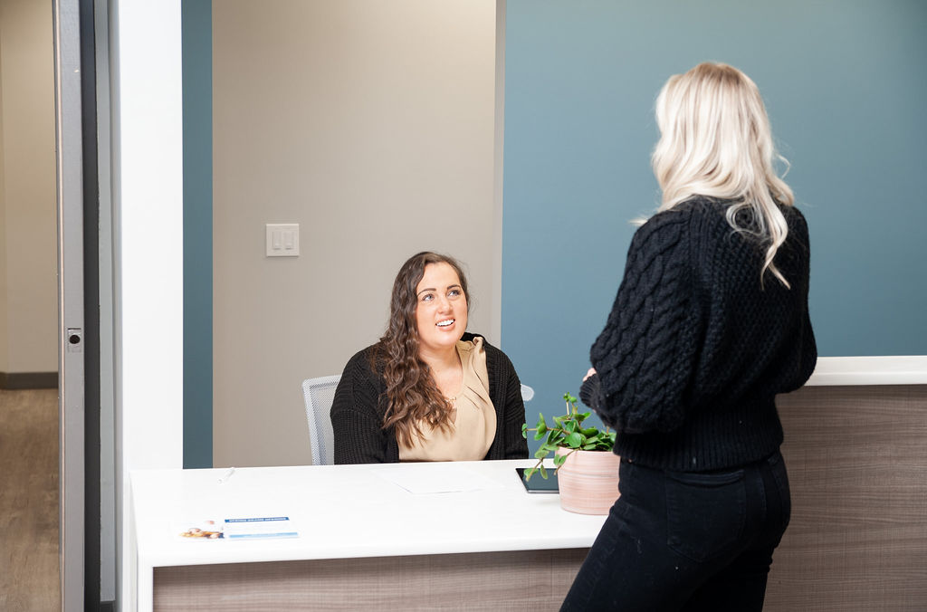 Two girls talking with each other at Blue Bridge Dental office
